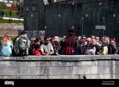 yeoman warder with tour group tower of london england Stock Photo - Alamy