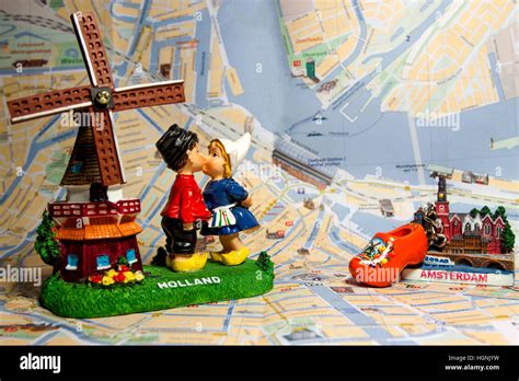 Holland souvenir with Amsterdam maps in background. Dutch windmill with kissing children. Dutch ...