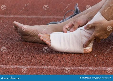 Male Athlete Applying Compression Bandage Onto Ankle Injury of a Football Player Stock Photo ...