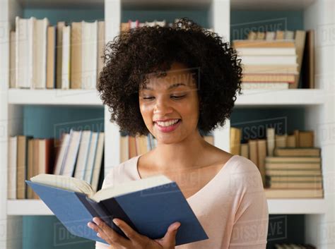 Woman reading book in library - Stock Photo - Dissolve