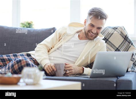 Young Man Lying on Sofa Stock Photo - Alamy