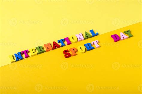 Wooden letters International Sports Day on a yellow background. 5327095 ...