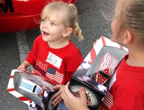 Military children receive large-scale Hot Wheels toy cars during an Operation Wheels of Freedom ...