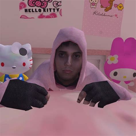 a man in a pink hello kitty outfit sitting on a bed with two stuffed animals