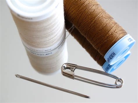 two white and brown sewing threads, needle and safety pin free image | Peakpx