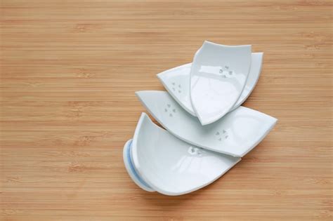 Premium Photo | Pieces of broken ceramic bowl on wood background.