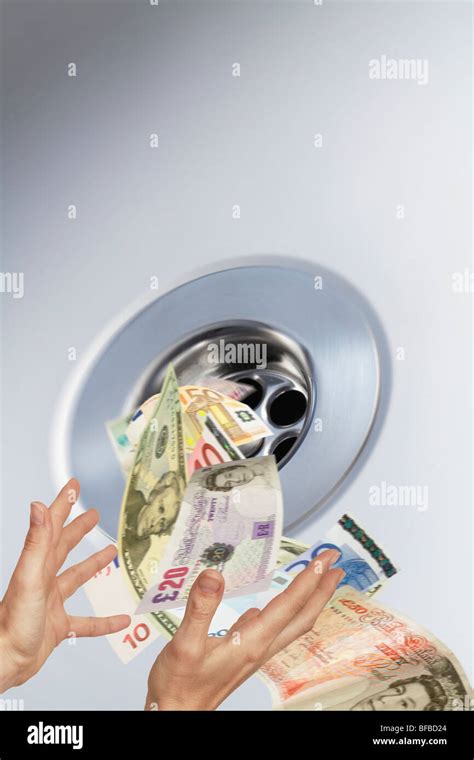 money going down the plughole into sink drain conceptual image Stock Photo - Alamy