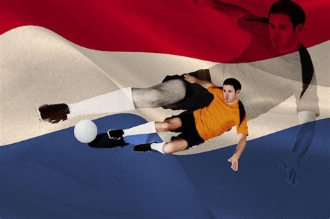 Premium Photo | Football player in orange kicking against digitally generated dutch national flag