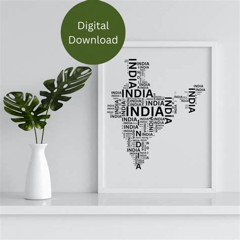 a white vase sitting on top of a table next to a framed poster with the word india written in ...