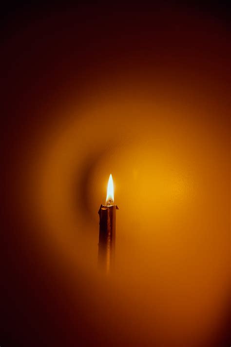 Close Up Photograph of Person Praying in Front Lined Candles · Free Stock Photo