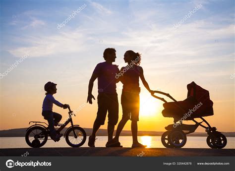 Happy family walking on sunset Stock Photo by ©yanlev 320442878