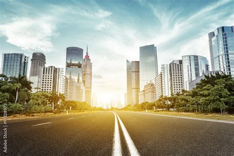 asphalt road and skyscrapers under sunbeam Stock Photo | Adobe Stock