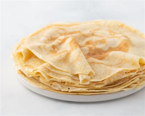 Crepes, thin pancakes with honey on a white plate. Marble background ...