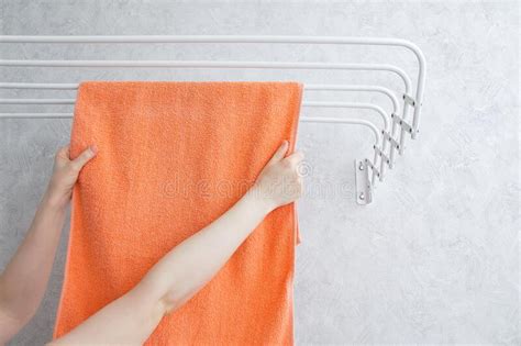 Hangs a Towel on Metal Wall-mounted Clothes Dryer. Hands of a Caucasian Woman Stock Image ...