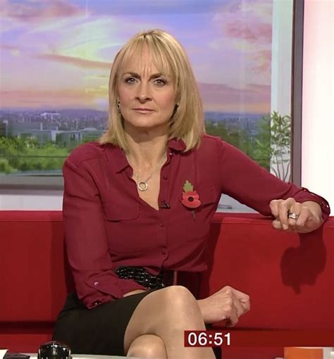 a woman sitting on a red couch in front of a tv screen with the news