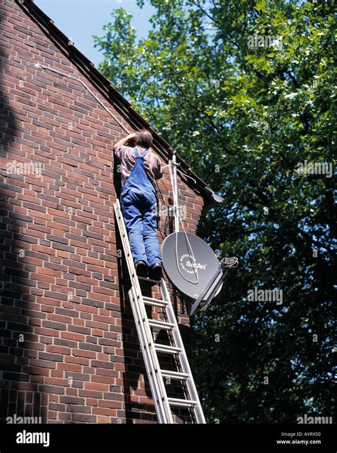 fitter assambles parabolic antenna at an outside wall, parabolic ...