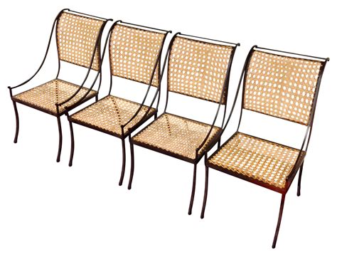 Set of four mid-century wrought iron and cane back chairs by John Vesey. The caning on several ...