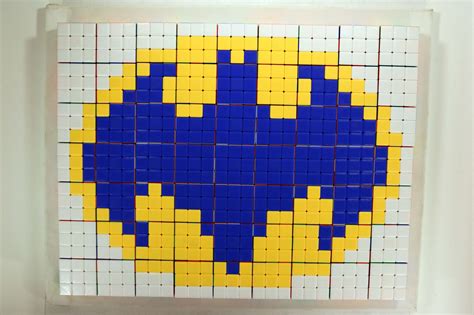 a blue and yellow square shaped artwork made out of legos on a white wall