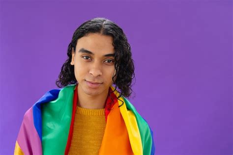 Retrato de homem biracial feliz segurando a bandeira do arco-íris lgbt ...