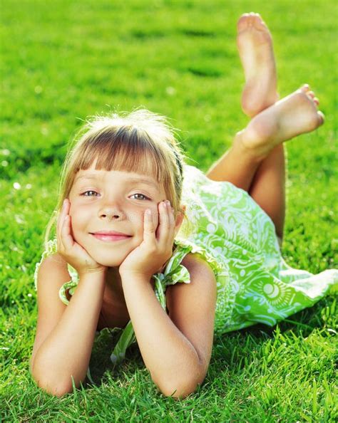 Cute Smiling Little Girl Lying on a Green Grass in the Park on a Stock ...