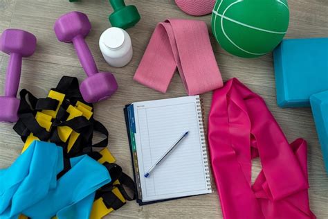 Premium Photo | Sports equipment in the form of weights dumbbell notebook pen on a colored mat ...