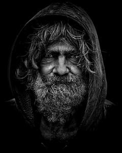 Royalty-Free photo: Grayscale photo man wearing hooded jacket with right hand showing hand sign ...