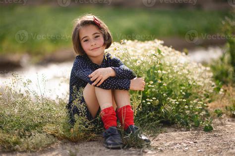 Little girl sitting in nature field wearing beautiful dress 4521116 Stock Photo at Vecteezy