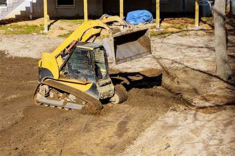 Premium Photo | Bulldozer moves soil digging ground doing landscaping works