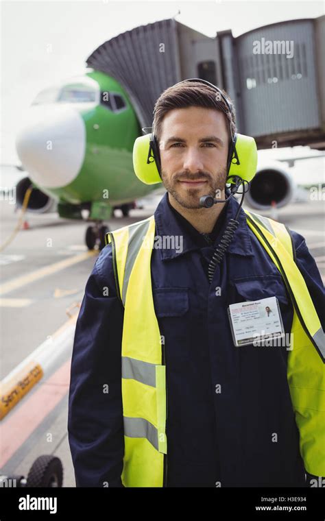 Portrait of airport ground crew standing on runway Stock Photo - Alamy