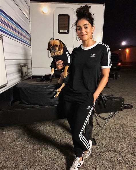 a woman standing next to a dog in front of a trailer