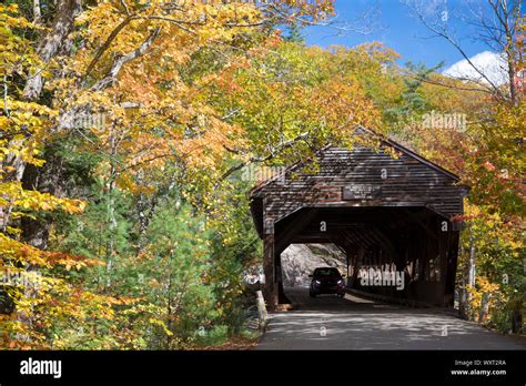 Auto driving through covered bridge along the Kancamagus Highway and Fall foliage in The White ...