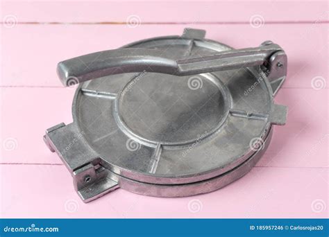 Metallic Manual Machine Tortilla Press on Pink Background Stock Photo - Image of plate ...