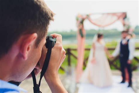 wedding photographer takes pictures of bride and groom in city. wedding couple on photo shoot ...