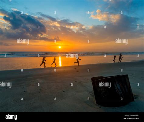 Silhouette of children running with sunrise background Stock Photo - Alamy