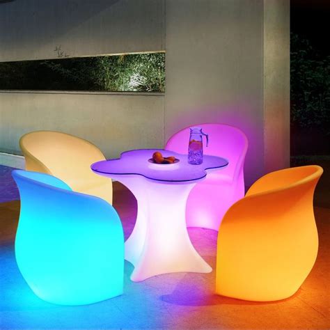 colorful chairs and tables are lit up at night