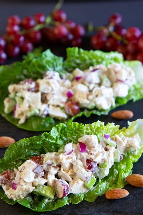 a close up image of creamy chicken salad inside of a romaine lettuce ...