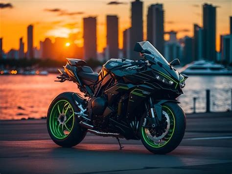 a motorcycle parked in front of a body of water with the sun setting ...