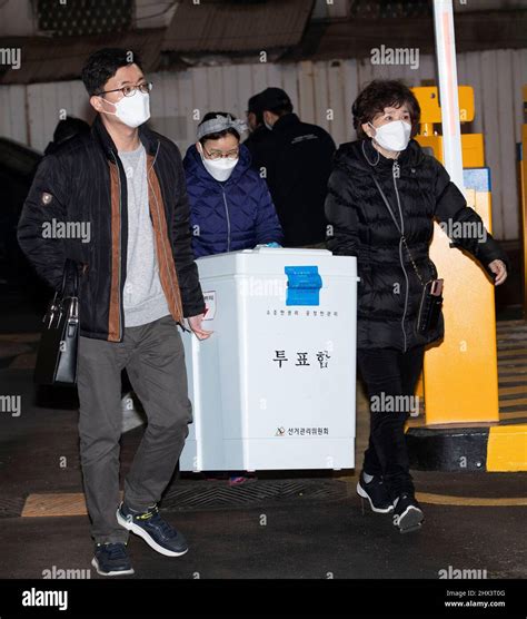 South Korean National Election Commission officials carry ballots boxes ...