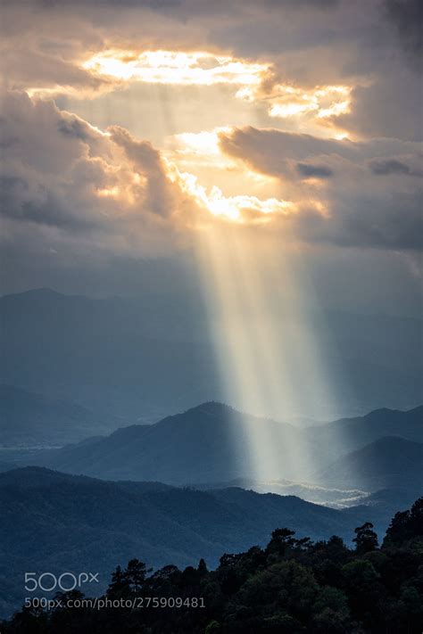 Sunlight shining through hole of clouds to dark mountain | Clouds, Dark ...