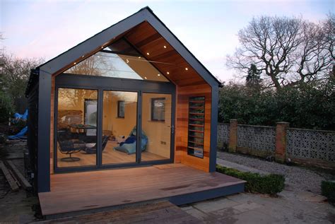 a small house with glass doors and wooden flooring in front of the ...