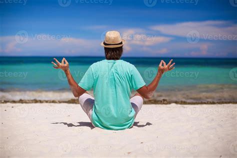 Man meditating on the beach 20469711 Stock Photo at Vecteezy