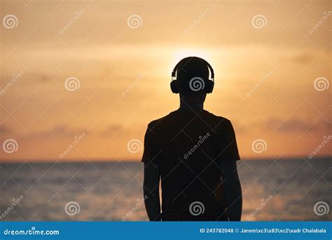 Silhouette of Man with Headphones Against Ocean Stock Photo - Image of ...