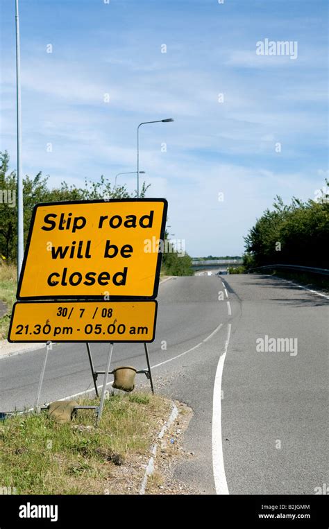 Yellow motorway maintenance sign warning of closed slip road on sunny ...