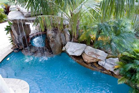 Lagoon pool and spa underneath grotto waterfall by Lucas Lagoons Inc.