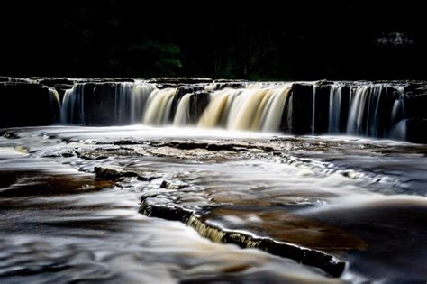 Premium Photo | A waterfall in the woods is a waterfall.