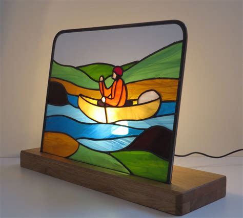 a stained glass lamp with a man in a boat