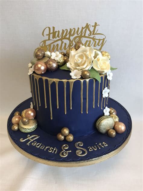 a blue and gold birthday cake with flowers on top