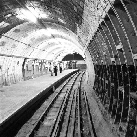 black and white photograph of train tracks in a tunnel