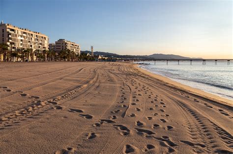 Premium Photo | The beach of badalona at sunrise with a footprints and ...