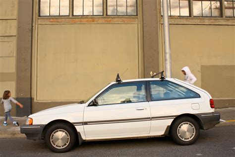 OLD PARKED CARS.: 1987 Mercury Tracer hatchback.